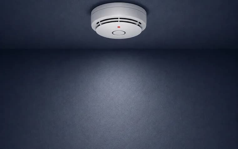 A hardwired combination smoke and carbon-monoxide alarm on a ceiling.